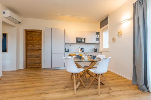 a kitchen and dining room with a table and white chairs at La Tizzana in Armeno
