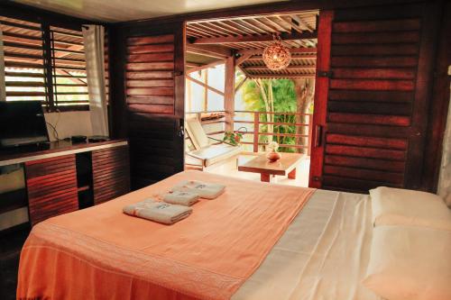 a bedroom with a bed with towels on it at Pipa Panorama Aparthotel in Pipa