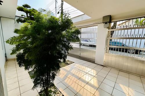 a building with a tree in the middle of a courtyard at 0003 - Pousada HG quarto home office single in Guarulhos