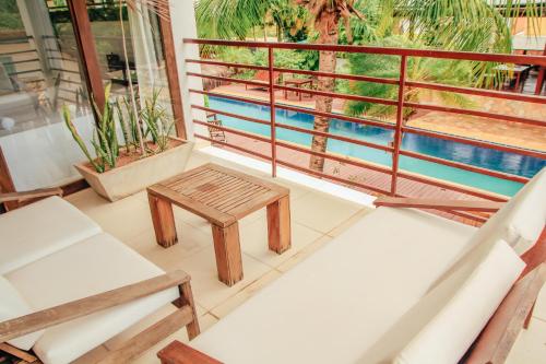 a balcony with a table and chairs and a pool at Pipa Panorama Aparthotel in Pipa