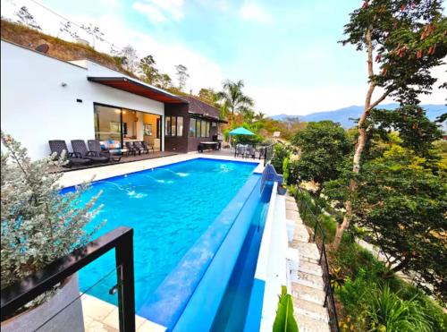 a swimming pool in front of a house at Hermosa Finca en Sopetrán in Sopetran