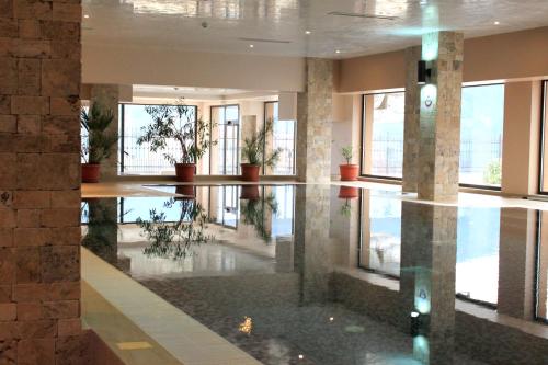 a lobby with potted plants and a reflection in the water at Park Hotel and SPA Vella Hills in Velingrad