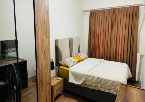 1 dormitorio con 1 cama en una habitación con espejo en Dimer country, en Beylikduzu