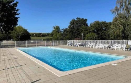 una piscina con sillas y una valla en Mobil-home, en Saint-Pair-sur-Mer