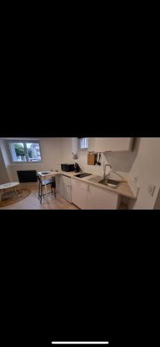 une cuisine avec des placards blancs et une table avec une chaise dans l'établissement Studio cosy Proche de la gare, à Valence