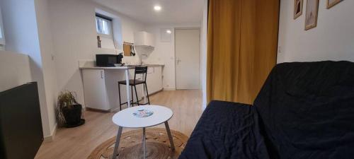 un petit salon avec une table et un canapé dans l'établissement Studio cosy Proche de la gare, à Valence