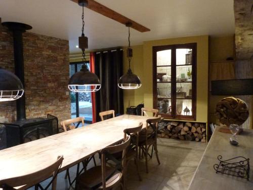 une salle à manger avec une grande table et des chaises en bois dans l'établissement LA Parenthèse II, à Athie
