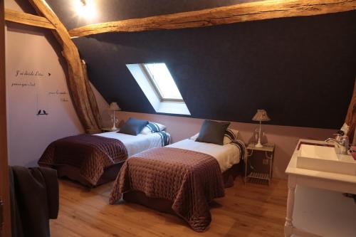 - une chambre avec 2 lits, une fenêtre et un lavabo dans l'établissement LA Parenthèse II, à Athie