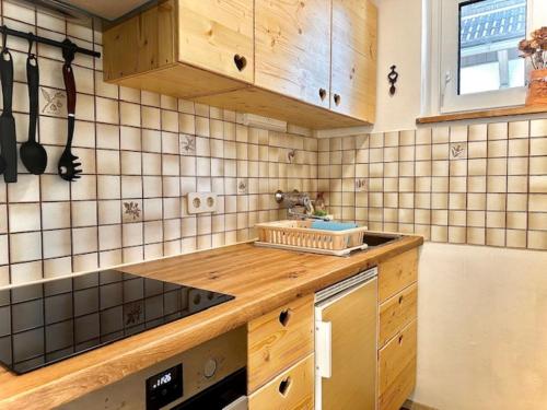a kitchen with wooden cabinets and a counter top at Alpenblick Apartment in Hermagor