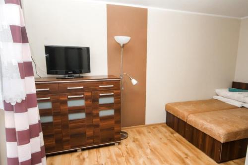 una camera da letto con un letto e una televisione su una cassettiera di Wielorybek Junior a Kąty Rybackie