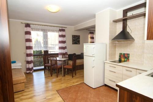 una cucina e una sala da pranzo con frigorifero bianco di Wielorybek Junior a Kąty Rybackie