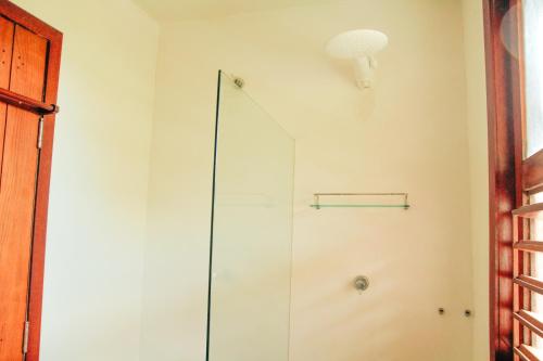 a shower in a bathroom with a glass door at Pipa Panorama Aparthotel in Pipa