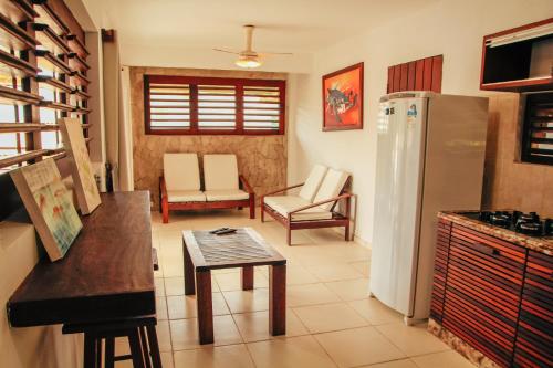 a kitchen with a refrigerator and a table and chairs at Pipa Panorama Aparthotel in Pipa