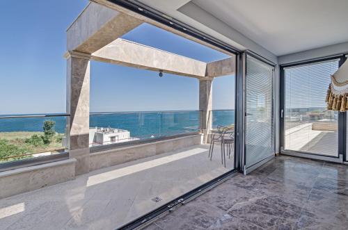 a room with a large window and a view of the ocean at Villa Ambra in Tyulenovo