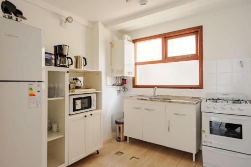 a kitchen with white appliances and a window at Gray Fox Apartments - Roca in Ushuaia