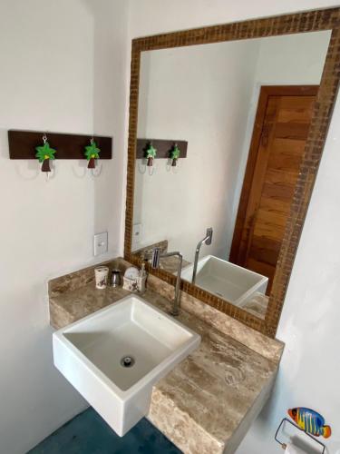 un bagno con lavandino e specchio di Villa Silva&Braga POUSADA arraial d'ajuda Bahia-VERDE a Arraial d'Ajuda