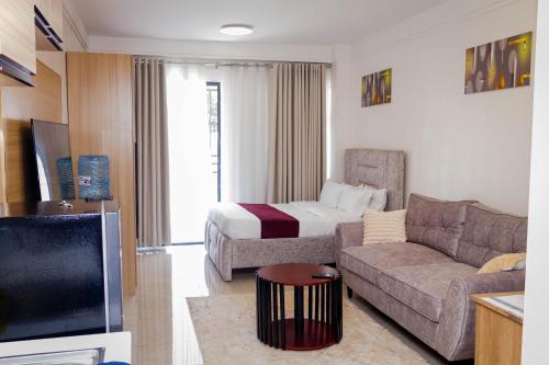 ein Wohnzimmer mit Sofa und Bett in der Unterkunft GRE homes Studio apartment in Ruaka