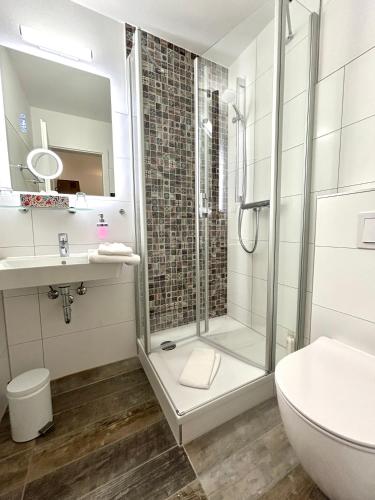 a bathroom with a shower and a toilet and a sink at Hotel Elefant in Schwerin