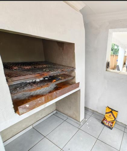 a kitchen with a brick oven in the wall at Azrisi Apartments in Kempton Park