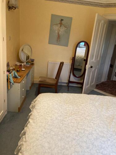 a bedroom with a bed and a vanity and a mirror at Country Mill House in Lawrencetown