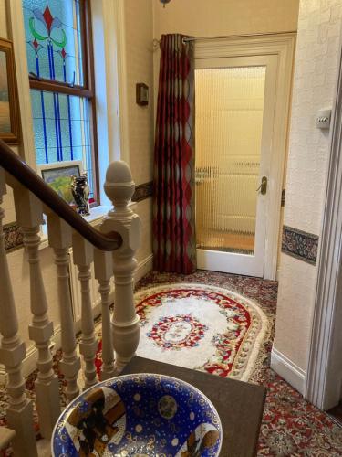 a hallway with a staircase with a blue and white bowl at Country Mill House in Lawrencetown