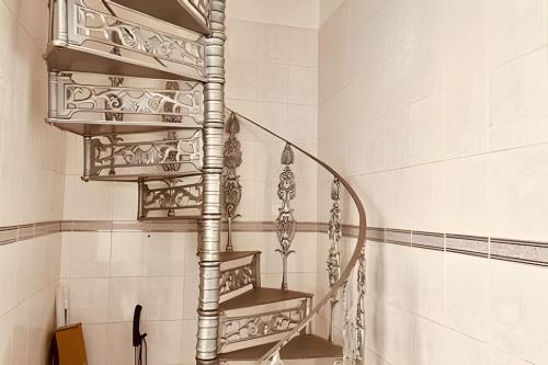 una escalera de caracol en un baño con azulejos blancos en 0005 - Pousada HG quarto home office single, en Guarulhos