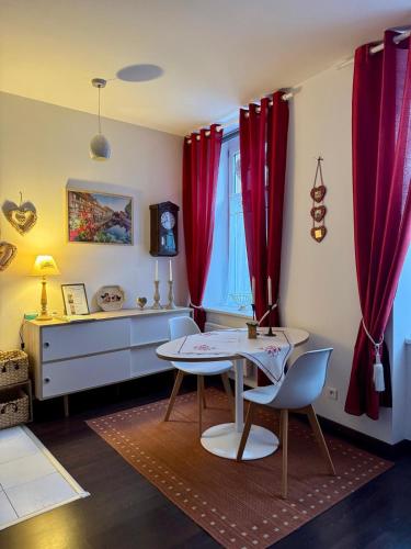 - une salle à manger avec des rideaux rouges, une table et des chaises dans l'établissement 