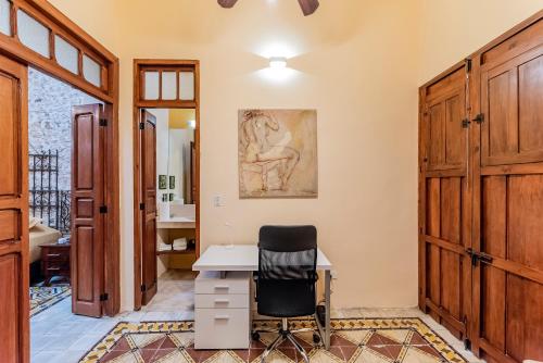 a home office with a desk and a chair at Casa La Escondida in Mérida