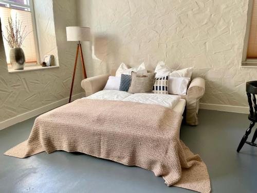 a bedroom with a bed with a blanket on it at stilvoll, gemütlich und ruhig - Bad Kösen - salt apartments in Naumburg