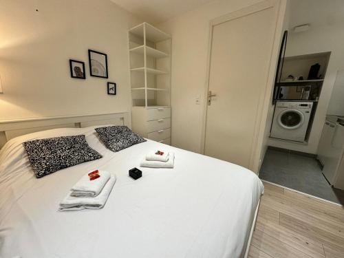 une chambre avec un lit blanc avec des serviettes dessus dans l'établissement Duruy G studio proche piscine et patinoire, à Reims