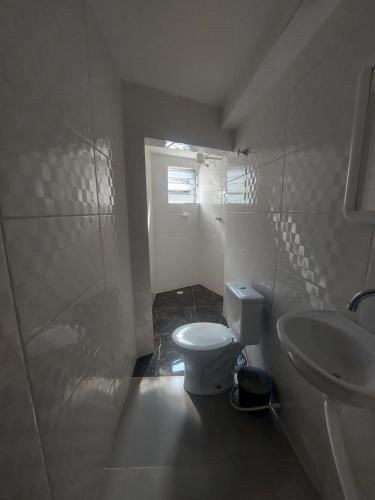 a white bathroom with a toilet and a sink at Hotel Estação - Osasco in Osasco