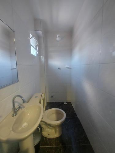a bathroom with a white toilet and a sink at Hotel Estação - Osasco in Osasco