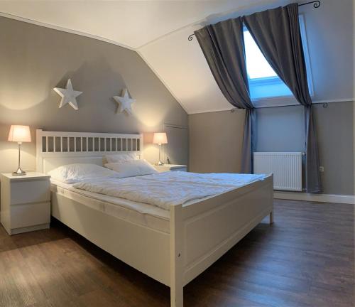 a bedroom with a large white bed with stars on the wall at Juli-Huus in Bastorf