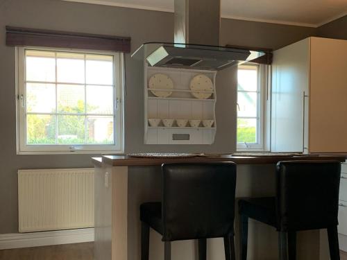a kitchen with a counter with two chairs and a microwave at Juli-Huus in Bastorf