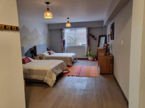 a bedroom with two beds and a window at Alojamiento San Francisco - Apartamentos y habitaciones in Lima