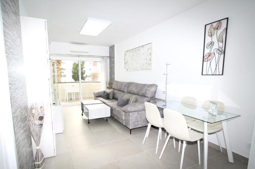 a living room with a glass table and a couch at Marvelous apartment in Playa del Ingles in Maspalomas
