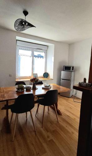 un salon avec une table et des chaises en bois dans l'établissement L'Agapanthe, Gîte au coeur de la Baie de Saint Brieuc, à Hillion