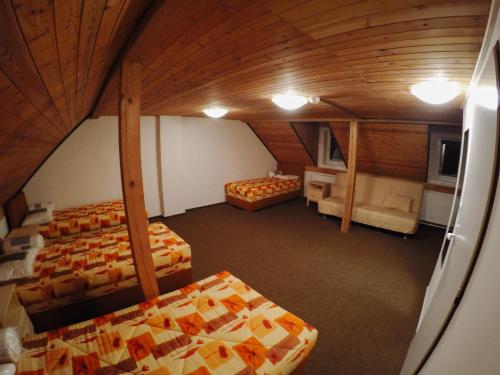 an attic room with three beds in a room at Hotel & Restaurant Adolfovský Dvůr in Adolfov