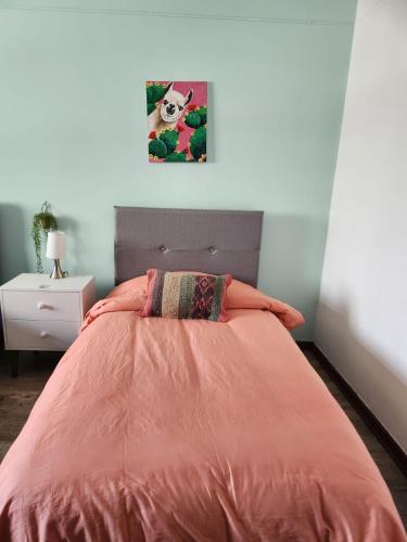 a bedroom with a bed with an orange comforter at Alojamiento San Francisco - Apartamentos y habitaciones in Lima