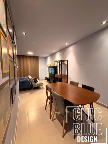 a dining room with a table and a couch at Chic Blue Design com Vaga de Garagem in Sao Paulo