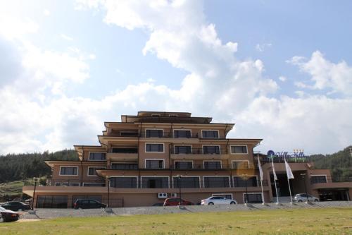 a large building with cars parked in front of it at Park Hotel and SPA Vella Hills in Velingrad
