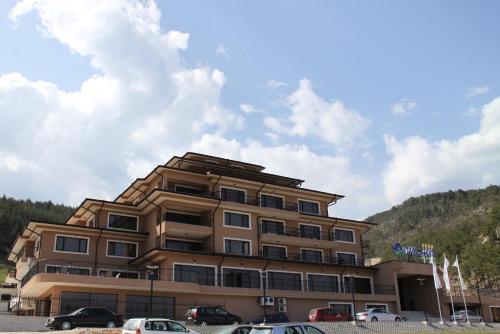 a large building with cars parked in front of it at Park Hotel and SPA Vella Hills in Velingrad