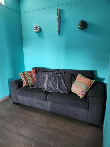 a couch in a room with a blue wall at Alojamiento San Francisco - Apartamentos y habitaciones in Lima