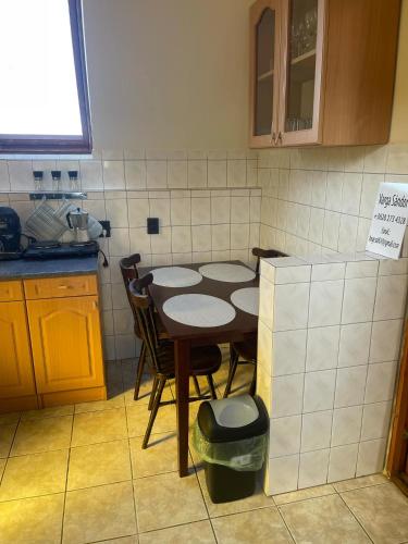 a kitchen with a table and chairs in it at Zorka Apartman in Kisapáti