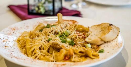 a plate of pasta with meat and cheese on a table at The Audubon Hotel in Sainte Genevieve