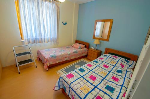 1 dormitorio con 2 camas, espejo y silla en Villa Alba en Kinira