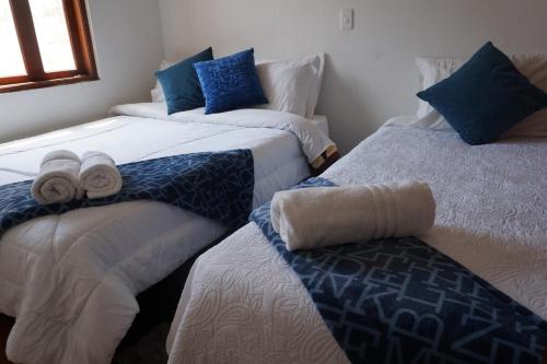 twee bedden in een kamer met handdoeken erop bij Hermoso Apartamento Faros de la Villa a 4 calles de la Plaza in Villa de Leyva