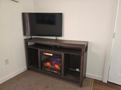 a entertainment center with a tv and a fireplace at The Happy Place in Glouster
