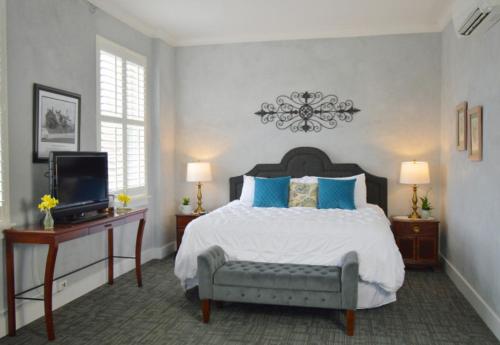 a bedroom with a large bed and a television at Hotel Audubon in Sainte Genevieve