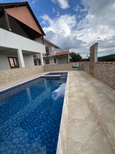 a swimming pool in front of a house at Casa 2 Chalé Alto dos Bandeirantes-Tiradentes in Tiradentes